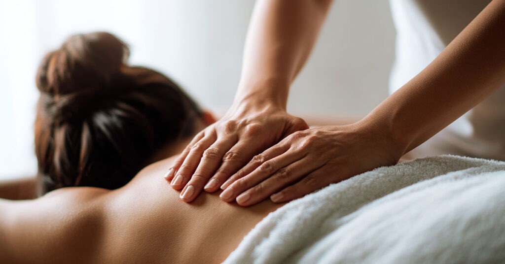 Massage therapist applying firm pressure to a client’s back to relieve muscle tension and back pain